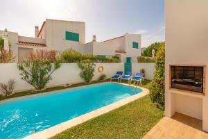 a villa with a swimming pool in front of a house at L&A Villa with Private heated Pool in Prainha in Alvor