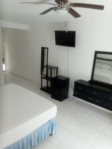 a bedroom with a bed and a flat screen tv at Negril Beach Club Condos in Negril