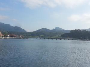 a bridge over a lake with mountains in the background at Hotel Ovetense in Oviedo