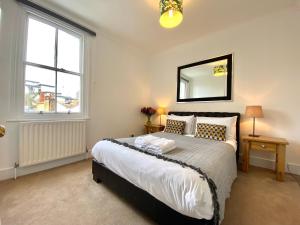 a bedroom with a bed and a mirror on the wall at Stylish Maisonette and Studio in Victoria in London