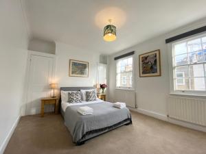 a bedroom with a bed and two windows at Stylish Maisonette and Studio in Victoria in London