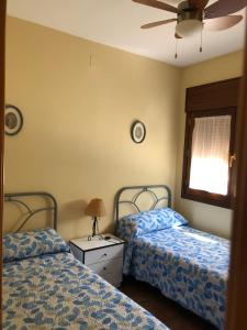 een slaapkamer met 2 bedden en een tafel met een lamp bij Casa Estribo in Arroyo Frio