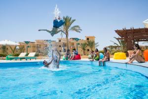 a group of people watching a person jumping in a swimming pool at Green Sudr Resort in Ras Sedr