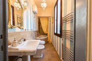 uma casa de banho com 2 WC e um lavatório e espelho em Firenze Rentals Deluxe Palmieri em Florença