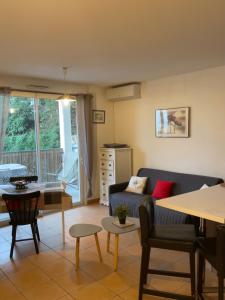 een woonkamer met een bank en een tafel bij Joli appartement tout confort in Hyères