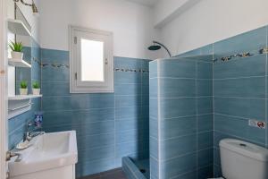 a blue tiled bathroom with a toilet and a sink at Villa Rodia with swimming pool on Skopelos Island in Skopelos Town +27 photos
