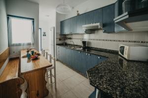 a kitchen with blue cabinets and a counter top at Casa Estribor, vacaciones en ambiente familiar in Punta de Mujeres