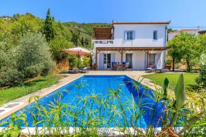 a villa with a swimming pool in front of a house at Villa Rodia with swimming pool on Skopelos Island in Skopelos Town
