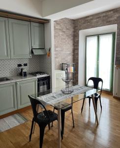 - une cuisine avec une table et des chaises dans la chambre dans l'établissement Una finestra sul centro storico, à Reggio d'Émilie