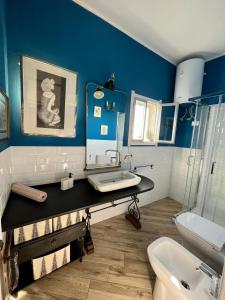 a blue and white bathroom with a sink and a toilet at Bombonera apartment in Augusta