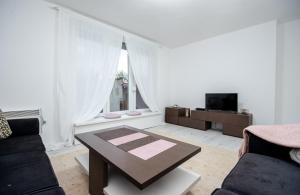 a living room with a coffee table and a tv at Apartment Kalemova in Sarajevo