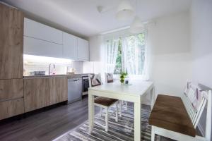 a kitchen with a white table and a dining room at Apartment Kalemova in Sarajevo