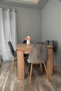 - une table à manger avec des chaises et un vase dans l'établissement luxury apartment st Demetrios downtown, à Thessalonique
