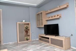 - un salon avec une télévision à écran plat dans un centre de divertissement en bois dans l'établissement luxury apartment st Demetrios downtown, à Thessalonique