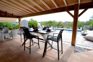 une terrasse avec une table, des chaises et une piscine dans l'établissement Villa Devaki, à Saint-François