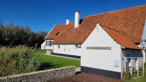 een wit huis met een rood dak bij Hoeve Spyckergoed in De Haan