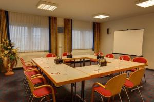 Una sala de conferencias con mesas, sillas y una pizarra. en Hotel Montana Lauenau, en Lauenau