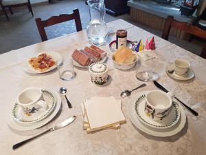 une table avec des assiettes, des tasses et de la nourriture dans l'établissement B&B La Rocca, à SantʼAgata Feltria