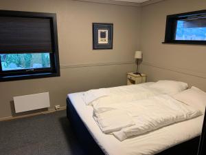 una camera da letto con un letto con lenzuola bianche e una finestra di Lom Apartment a Lom