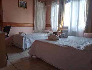 烏斯懷亞的住宿－Departamentos Paisaje del Beagle，酒店客房设有两张床和窗户。