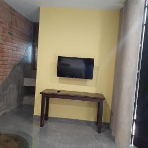 a room with a tv on a wall with a table at Loft con Jardín amplio 3 in Puerto Vallarta +13 photos