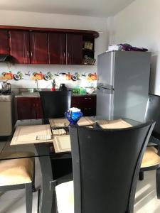 uma cozinha com uma mesa com cadeiras e um frigorífico em Cabaña La Blanquita em San Bernardo del Viento