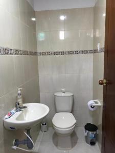 ein Badezimmer mit einem weißen WC und einem Waschbecken in der Unterkunft Cabaña La Blanquita in San Bernardo del Viento