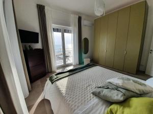 a bedroom with a large bed with a balcony at BELLAVISTA CASA SUL MARE in Salerno