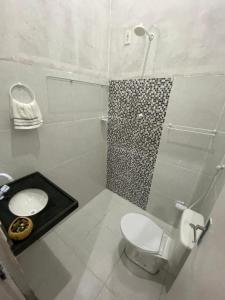 a white bathroom with a toilet and a shower at Pousada Vila do Mar in Taíba