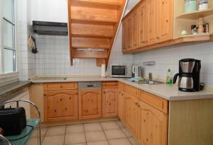 a kitchen with wooden cabinets and a counter top at Altes Backhaus in Groß Zicker