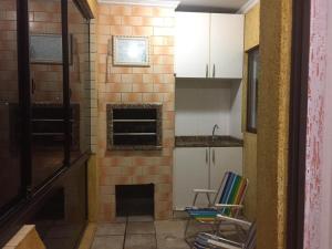 une cuisine avec deux chaises et une cheminée dans l'établissement APARTAMENTO 3 DORM., O QUINTAL É A PRAIA E MOLHES, à Laguna 12 autres photos
