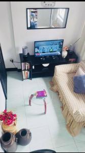 sala de estar con TV y mesa en Estien's cozy home, en Malagasang Primero