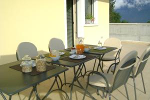 una mesa negra con sillas y bebidas. en Affittacamere Rubino Guest House, en Ponte nellʼAlpi
