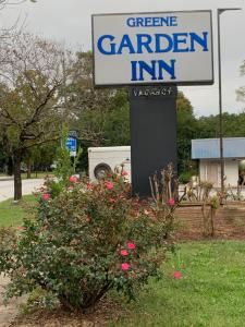 a sign for a garden inn next to a bush at Green Garden Inn in Greensboro