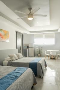 a bedroom with two beds and a ceiling fan at Paz-2 Norte estudios in Playa del Carmen +16 photos