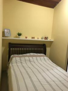 ein Bett in einem Schlafzimmer mit einem Regal an der Wand in der Unterkunft WINTERVILLE GRAVATá in Gravatá