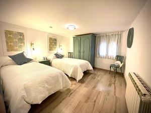 a bedroom with two beds and a green cabinet at El Refugio del Cierzo in Vera de Moncayo
