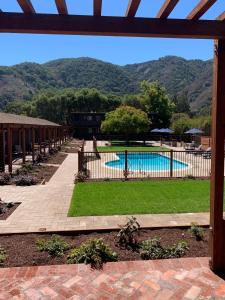 a pool with a fence and mountains in the background at Hidden Valley Inn in Carmel Valley