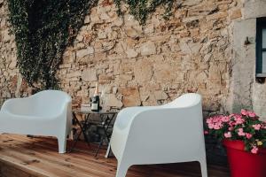 two white chairs and a table in front of a stone wall at Suite Sur Le Mont in Durbuy +8 photos