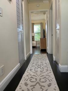 a hallway with a white rug on the floor at Cozynest2 in Boynton Beach