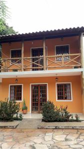 pomarańczowy dom z oknami i roślinami przed nim w obiekcie Casa Laranja Lençóis - BA w mieście Lençóis