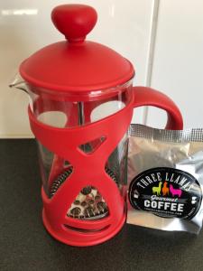 a red coffee pot with a red handle on a table at Teviot View Accommodation in Amberley