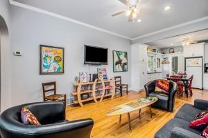 a living room with two couches and a tv at Hydrangea House in New Buffalo