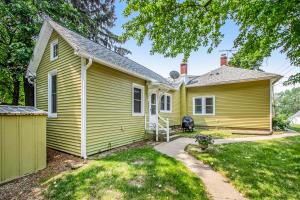 una casa amarilla con patio en Hydrangea House, en New Buffalo