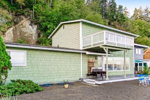 una casa verde con balcón en la parte superior. en Whidbey Shores waterfront retreat, en Langley