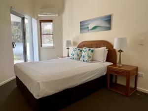 a bedroom with a large bed and a window at The Byron Beachcomber in Byron Bay +29 photos