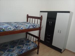 a bedroom with two bunk beds and a dresser at Bruno Conde Casa na praia in Ubatuba