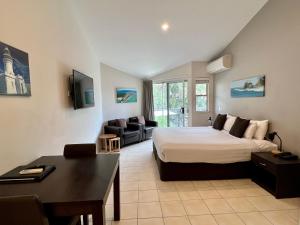 a bedroom with a bed and a living room at The Byron Beachcomber in Byron Bay