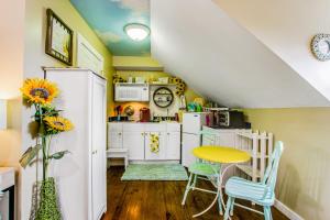 una pequeña cocina con mesa amarilla y sillas en The Studio On Taylor, en Savannah