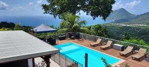 una casa con piscina su una terrazza con vista di Les hauts du fromager a Le Diamant